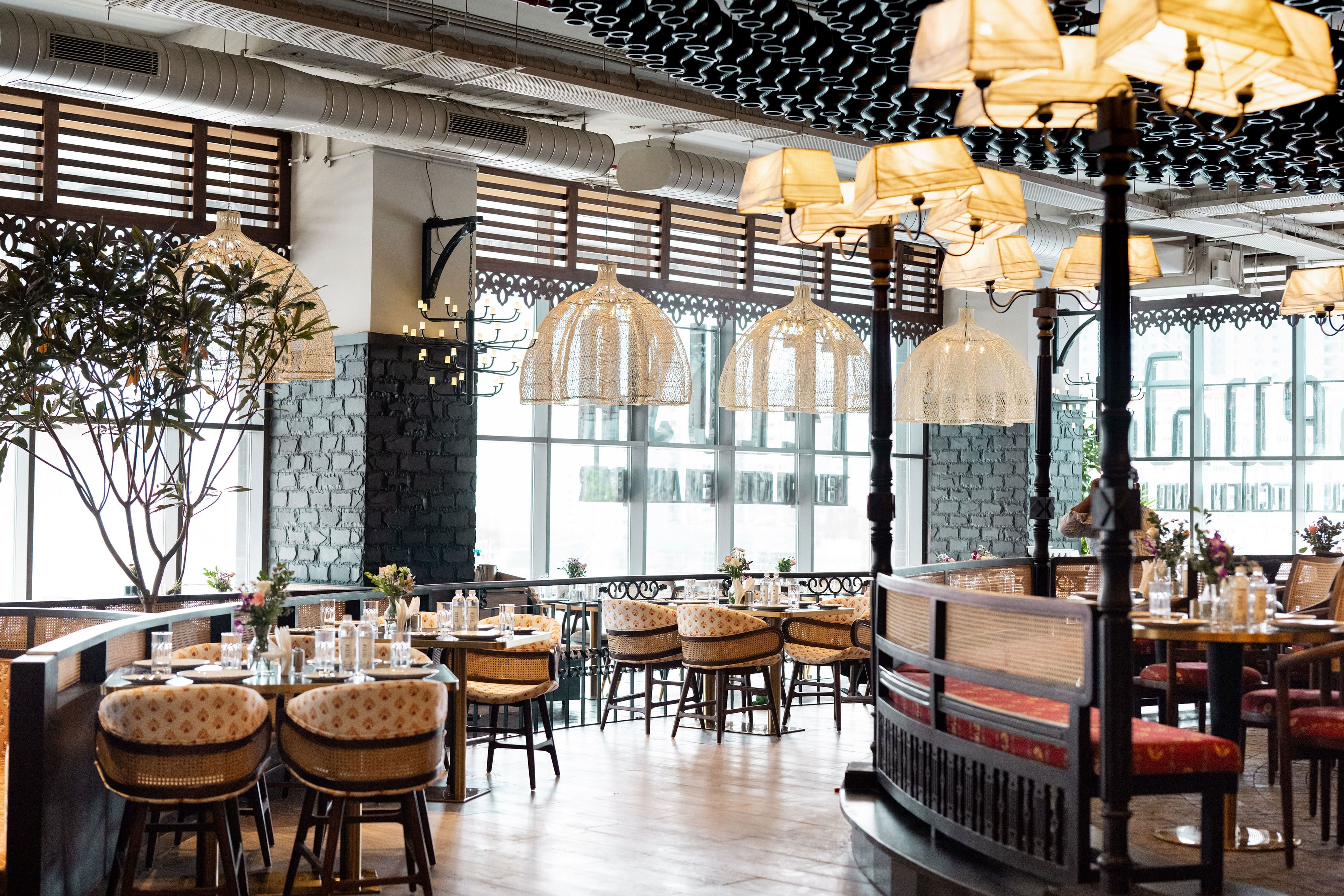 Evening inside Telusa — warm lamps, craft-lined walls and set tables